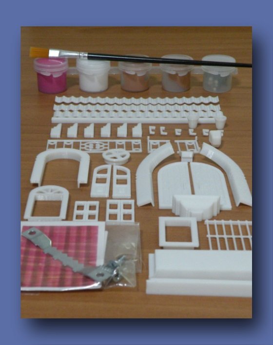 Piezas blancas de la mini fachada y pincel incluidos en el kit completo de manualidad